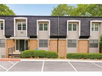 Traditional condo exterior with brick accents, multiple windows, and manicured shrubbery at 345 Winding River Dr # F, Atlanta, GA 30350