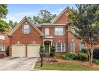 Charming two-story brick home featuring an attached two car garage, manicured lawn, and a welcoming front entrance at 2132 Wrights Mill Ne Cir, Atlanta, GA 30324