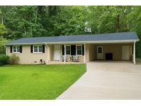Charming single-story home with manicured lawn, black shutters, and covered parking in a lush setting at 3854 Bright Star Road, Douglasville, GA 30135