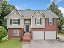 Two-story home featuring a brick and siding exterior, two-car garage, and landscaped front yard at 173 Cline Smith Ne Rd, Cartersville, GA 30121