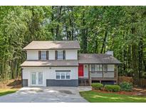 Charming two-story home featuring a welcoming porch and a vibrant red front door at 630 Pennylake Ct, Stone Mountain, GA 30087