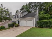 Charming two-story home features a two-car garage and well-maintained lawn at 1790 Abinger Ln, Lawrenceville, GA 30043