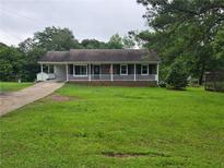 Charming home with a covered front porch and well-maintained lawn at 1997 Villa Rica Hwy, Dallas, GA 30157