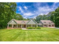 Charming home with a well-manicured lawn, stone accents, and a matching garage building at 2680 Bay Ridge Dr, Loganville, GA 30052