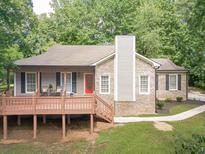Charming home boasts a cozy front porch, brick accents, and a red front door at 3329 Walt Stephens Rd, Stockbridge, GA 30281