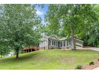 Charming home with brick accents, lush landscaping, and a lovely elevated wooden deck at 3329 Walt Stephens Rd, Stockbridge, GA 30281