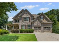 Charming brick home featuring a well-manicured lawn and a convenient two-car garage at 4120 Abingdon, Cumming, GA 30041