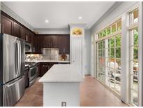 Modern kitchen boasts stainless steel appliances, dark cabinetry, and a bright quartz countertop island at 1055 Piedmont Ne Ave # 106, Atlanta, GA 30309