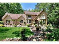 Charming brick home with well-manicured lawn and landscaping, nestled among mature trees at 4853 Carlene Sw Way, Lilburn, GA 30047