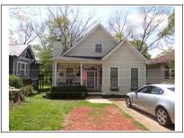 Charming home with a welcoming front porch, American flag, and a silver car parked in the driveway at 1378 Lucile Sw Ave, Atlanta, GA 30310