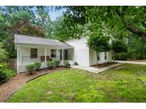 Charming home featuring a classic design, landscaped front yard, and a welcoming front porch with black metal railing at 215 Ansley Ct, Roswell, GA 30076