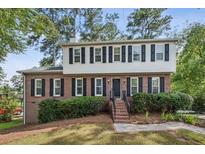 Charming two-story home featuring a brick facade, white siding, black shutters, and a well-manicured front yard at 3220 Casteel Rd, Marietta, GA 30062