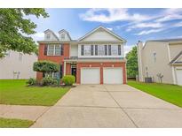 Charming two-story home with a brick facade, two-car garage, and well-maintained landscaping at 2011 Wildcat Lake Ct, Lawrenceville, GA 30043