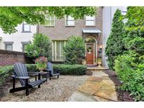 Charming brick townhome with a beautifully landscaped front yard and cozy seating area at 3163 Neal Ct, Cumming, GA 30041