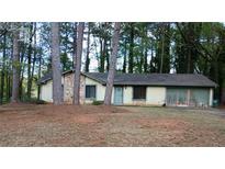 Quaint single-story home with stone accents and mature trees in a wooded suburban setting at 3182 Westbrook Trce, Lawrenceville, GA 30044