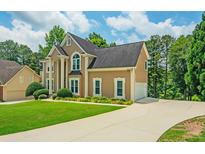 Elegant two-story home featuring a spacious driveway and meticulously manicured lawn at 2521 Wood Creek Ct, Dacula, GA 30019