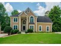 Charming two-story home with manicured lawn, columns at the entrance, and a welcoming, classic facade at 2521 Wood Creek Ct, Dacula, GA 30019
