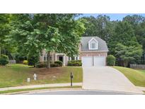 Charming brick home with a two-car garage, manicured lawn, and mature trees in a desirable neighborhood at 2934 Mill Grove Ter, Dacula, GA 30019