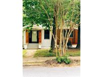 Charming renovated bungalow featuring white painted brick, wood accents, and a welcoming front porch in a lush, green setting at 1460 Hartford Sw Ave, Atlanta, GA 30310