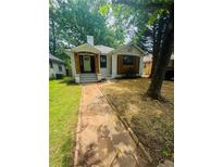 Charming single-Gathering home featuring a stone walkway, lawn, and trees at 1460 Hartford Sw Ave, Atlanta, GA 30310
