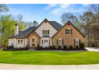 Beautiful two-story home featuring stone and siding exterior, well-manicured lawn, and charming curb appeal at 2410 Glade Overlook, Cumming, GA 30041