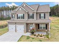 Charming two-story home boasts a welcoming porch, two-car garage, and beautiful curb appeal at 31 Village Trce, Rydal, GA 30171