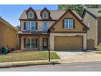 Charming two-story home featuring a brick facade, dormer windows, and a well-maintained lawn at 2638 Lake Manor Cir, Duluth, GA 30096