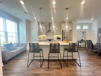 Bright, open-concept kitchen featuring a large island, stainless steel appliances, and pendant lighting at 500 Healy Dr # 77, Cumming, GA 30040