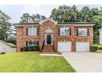Beautiful two-story brick home with a well-manicured lawn and two-car garage at 6118 Arbor Links Rd, Lithonia, GA 30058