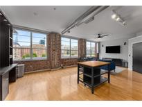 Open living area featuring exposed brick walls and large windows, providing an abundance of natural light at 800 Peachtree Ne St # 8612, Atlanta, GA 30308