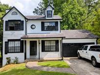 Charming two-story home with black trim, attached garage, and a well-manicured front lawn at 3087 Drexel Ln, Jonesboro, GA 30236