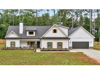 Charming two-story white farmhouse with black trim, dark roof, and a welcoming front porch at 3088 Hiram Sudie Road, Hiram, GA 30141