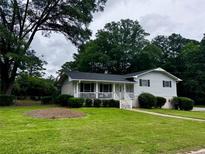 Charming single-Gathering home with a covered front porch and a well-maintained lawn at 3835 Clearwater Dr, Atlanta, GA 30349