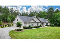 Charming single-story home with manicured lawn, lush landscaping, and an expansive driveway at 188 Macedonia Rd, White, GA 30184