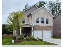 Charming two-story home with a stone and brick facade, a well-manicured lawn, and a two-car garage at 1961 Ecoland Dr, Grayson, GA 30017