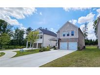 New two-story home featuring stone and brick facade, two-car garage, and manicured lawn on a sunny day at 1961 Ecoland Dr, Grayson, GA 30017