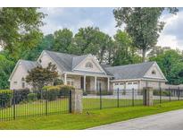 Lovely brick home featuring manicured landscaping, an attached two-car garage, and an elegant, gated entrance at 4829 Moon Rd, Powder Springs, GA 30127