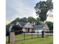 Charming brick home features a well-manicured front yard and a black wrought iron fence at 4829 Moon Rd, Powder Springs, GA 30127