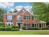 Charming two-story brick home with manicured lawn, black shutters, and mature landscaping at 9744 Spyglass Dr, Villa Rica, GA 30180