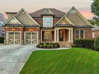 Stunning brick home with a well-manicured lawn and inviting curb appeal at 4050 Bonnett Creek Ln, Hoschton, GA 30548