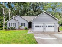 Charming home featuring a well-maintained front yard, two-car garage, and classic curb appeal at 112 Laguna Springs Dr, Woodstock, GA 30188