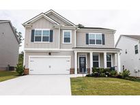 Charming two-story home with a well-maintained lawn, two car garage, and a welcoming front porch at 895 Garnet Dr, Acworth, GA 30101