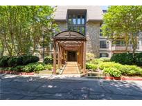 Beautiful stone building entrance with a covered walkway surrounded by lush landscaping at 1120 Highland Bluff Se Dr, Atlanta, GA 30339