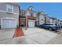 Charming townhome showcases a brick front, single-car garage, and a well-maintained driveway at 2189 Executive Dr, Duluth, GA 30096