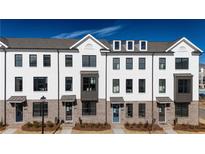 Modern townhome exterior showcases white brick, multiple windows, and stylish architectural details at 621 Silva St # 124, Cumming, GA 30040
