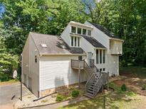 Bright multi-story home with wood siding, inviting entrance staircase, and attached garage at 4528 Lashley Ne Ct, Marietta, GA 30068