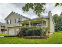 Charming two-story home featuring a welcoming front porch, a two-car garage, and a well-maintained lawn at 520 White Pines Dr, Dallas, GA 30157