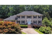 Charming brick two-story home with brick driveway, landscaped yard, and mature trees at 5349 Forest Springs Dr, Dunwoody, GA 30338