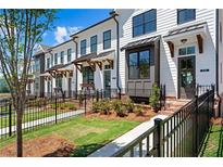 Charming townhouse with white siding, black trim, and landscaped front yard at 630 Skytop Dr # 157, Cumming, GA 30040