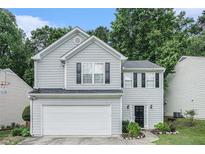 Charming two-story home with light gray siding, black shutters, a two-car garage, and lush landscaping at 2512 Halcyon Way, Lawrenceville, GA 30044